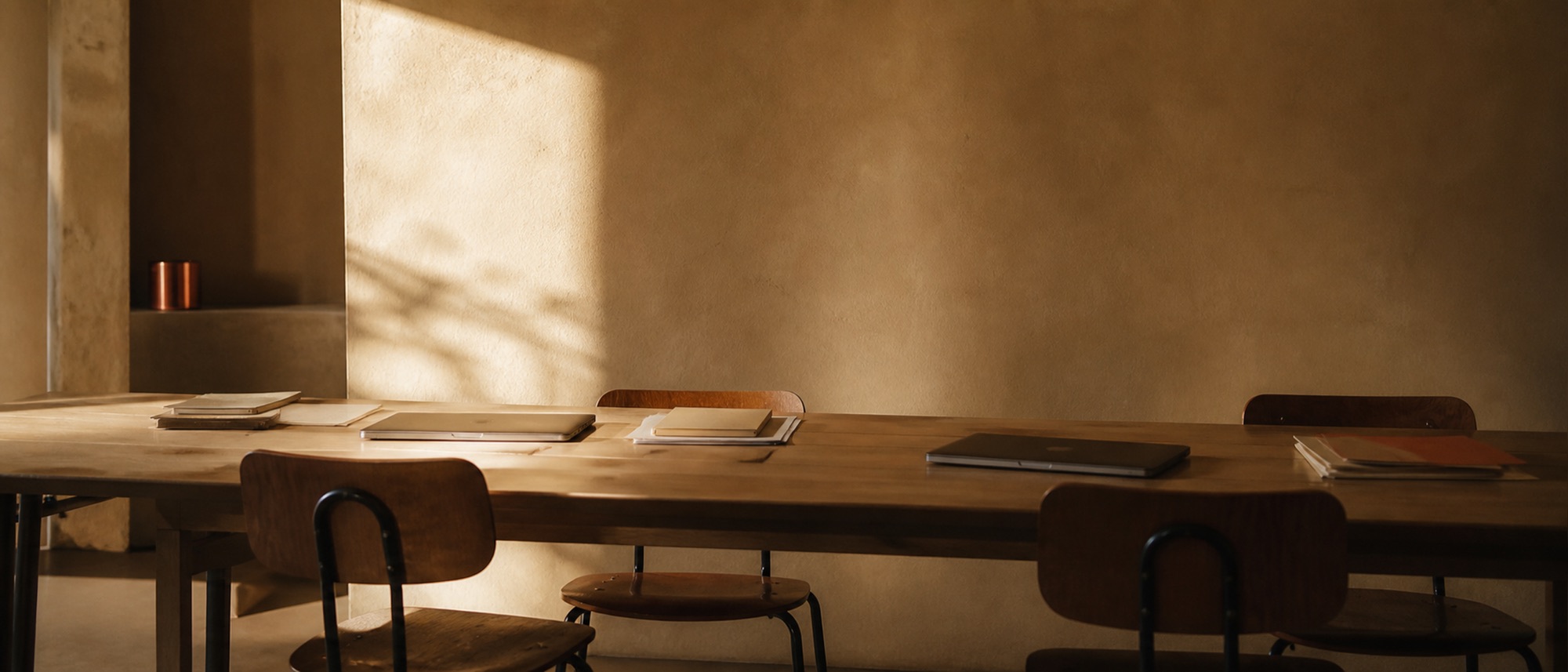 A long work table in a quiet studio, morning light across the surface.